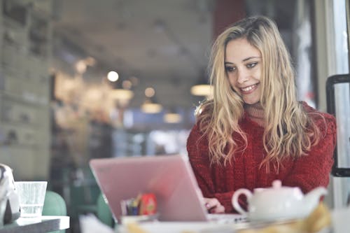 Free Woman in Red Sweater Sitting by the Table Stock Photo