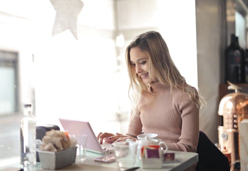 Free Woman In Brown Long Sleeve Using A Laptop Stock Photo