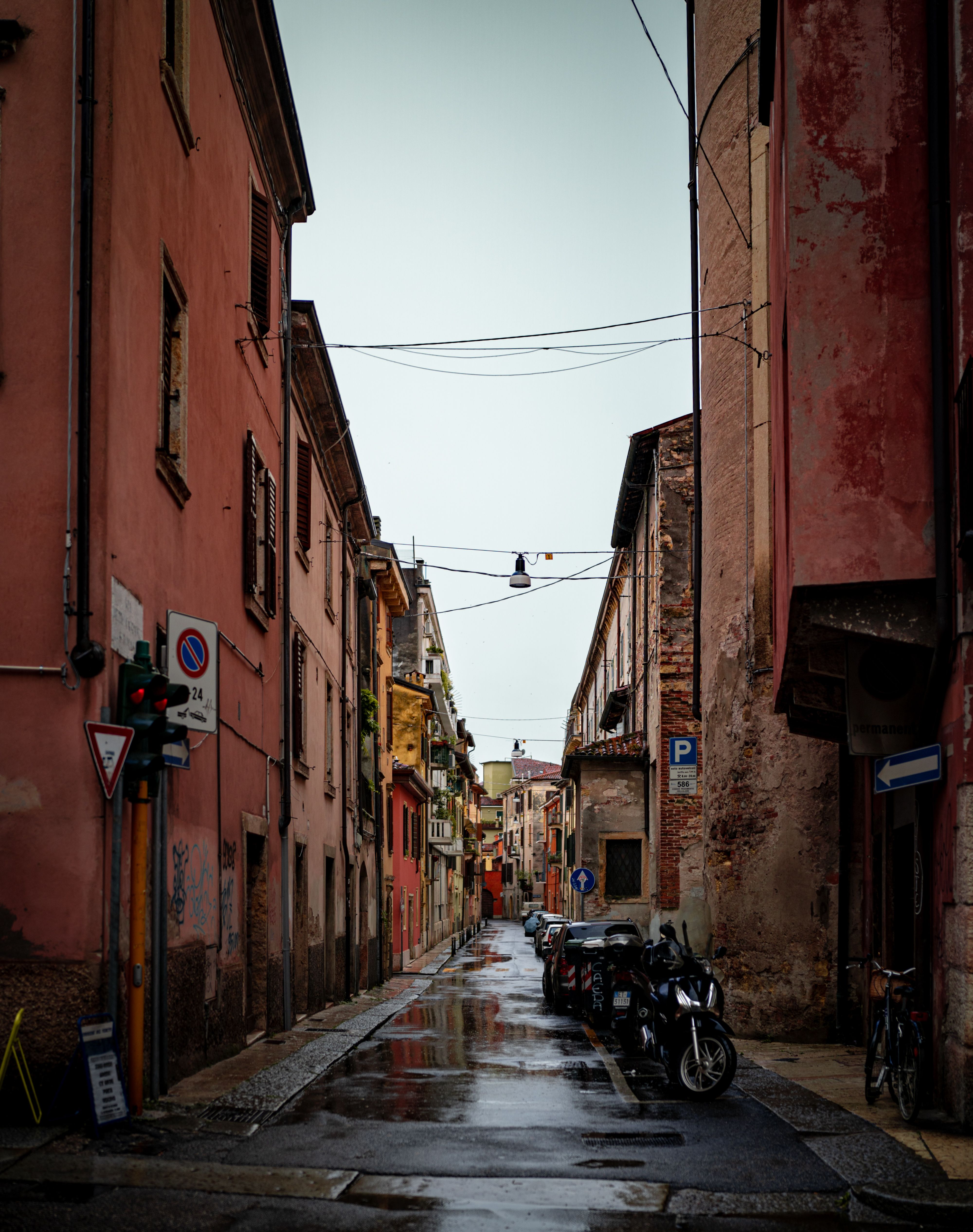 Gratis Una splendida e stretta via di Verona, con edifici colorati e marciapiede bagnato dopo un acquazzone. Foto a disposizione