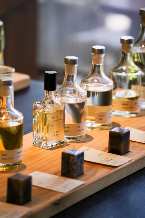 Free A stylish arrangement of scented diffuser bottles on a wooden tray with light and shadows. Stock Photo