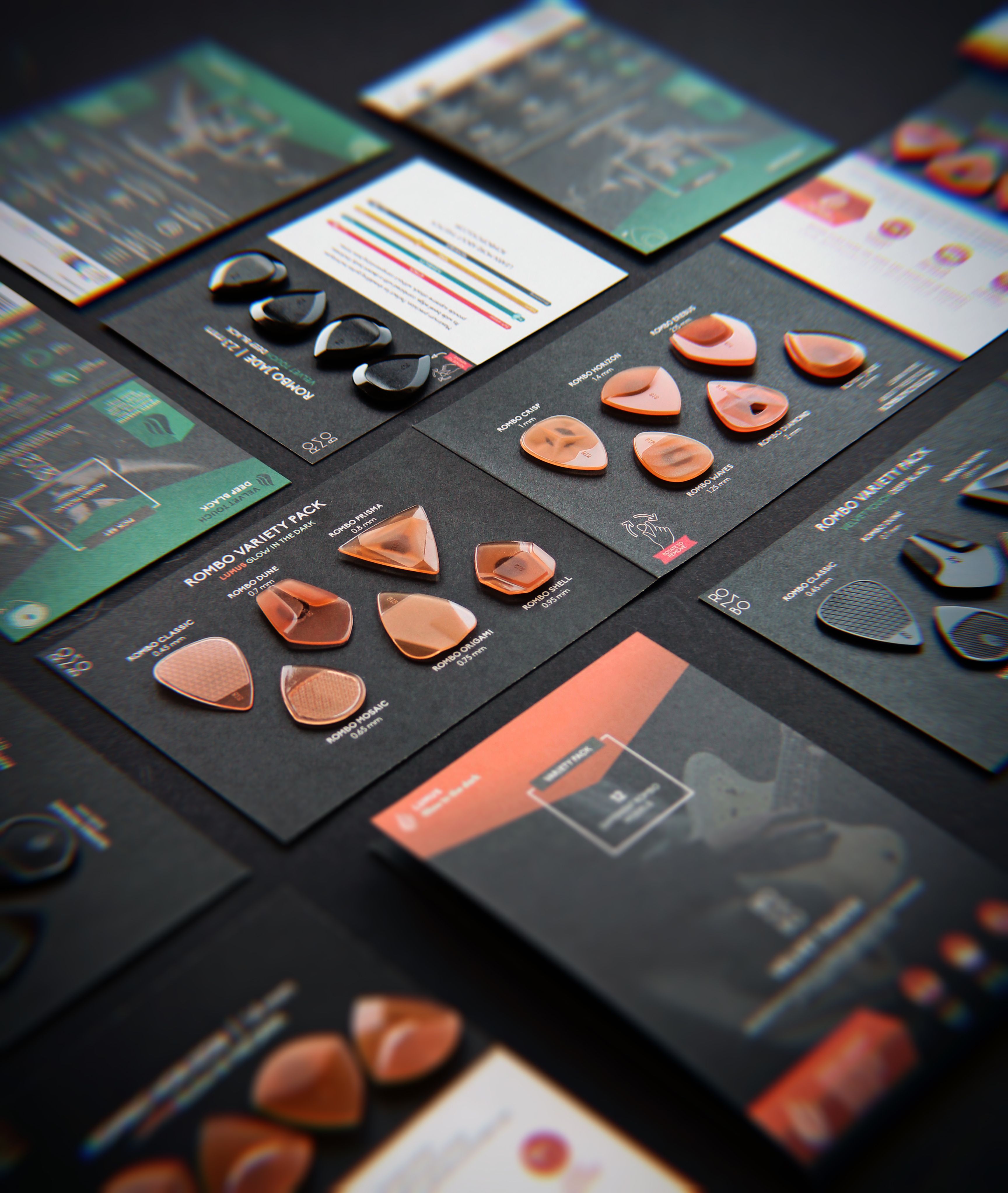 A variety of guitar picks arranged on cards in a stylish display on a black surface.