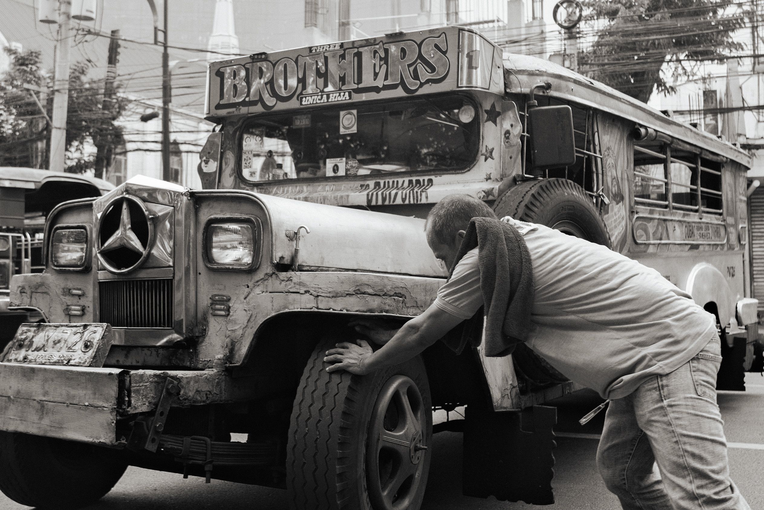 Mechanic Repairing Iconic Philippine Jeepney · Free Stock Photo