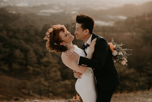 Free Man in Black Suit Kissing a Woman in White Dress Stock Photo