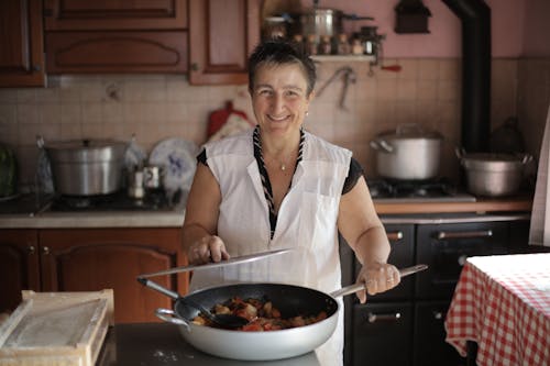 Ücretsiz Beyaz Düğmeli Gömlekli Yaşlı Kadın Lezzetli Bir Yemek Pişirmiş Stok Fotoğraflar