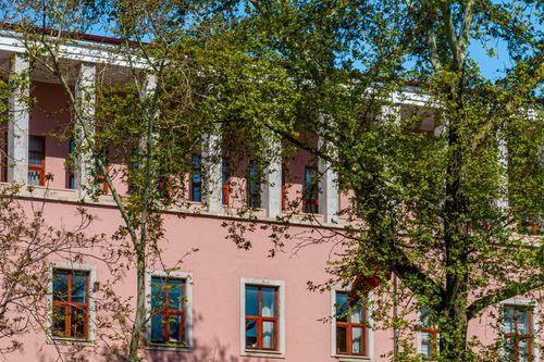 Free A serene architectural view of a pink building surrounded by lush green trees during spring in Ankara, Türkiye. Stock Photo