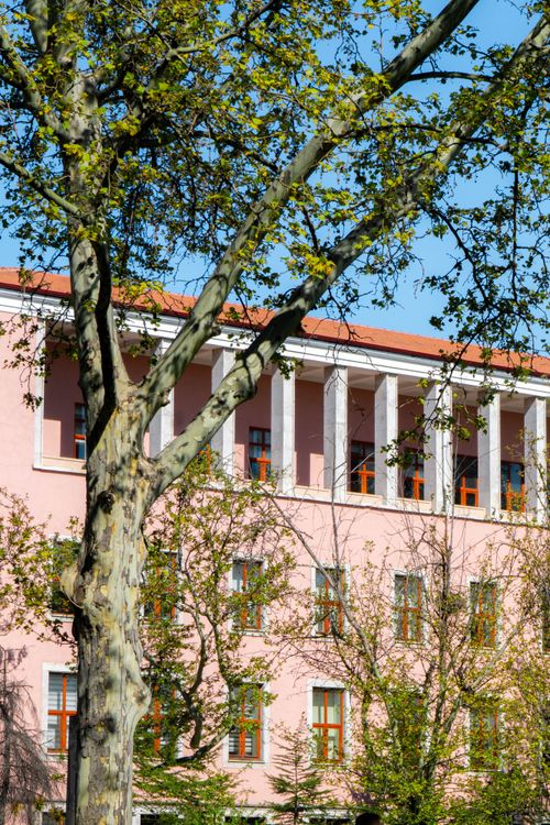 Free A pink historic building surrounded by trees in springtime, located in Ankara, Türkiye. Stock Photo