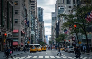 A city street canyon between tall buildings in the early morning
