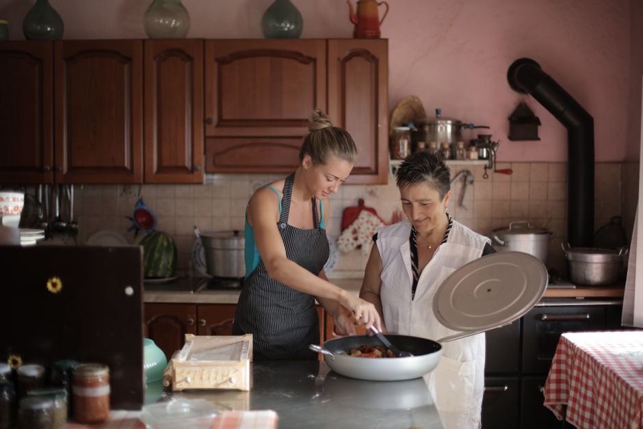 Mother and daughter enjoy cooking together in a cozy, rustic kitchen setting. - 7 Viral Kitchen Inventions That Make Solo Cooking and Meal Prep Fun Again