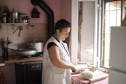 Woman in White Apron Standing in Kitchen