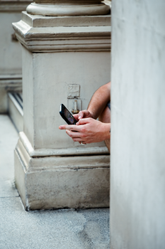 Hands holding a smartphone in an urban setting, highlighting modern technology and lifestyle.