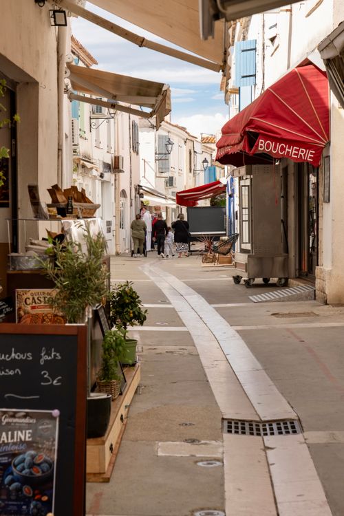 Free Picturesque French alley lined with shops and a boucherie awning. Stock Photo