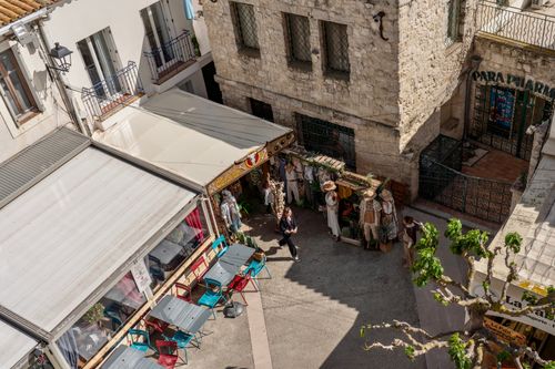 Free Charming view of a European street with a cafe, offering a vibrant atmosphere and sunny day. Stock Photo