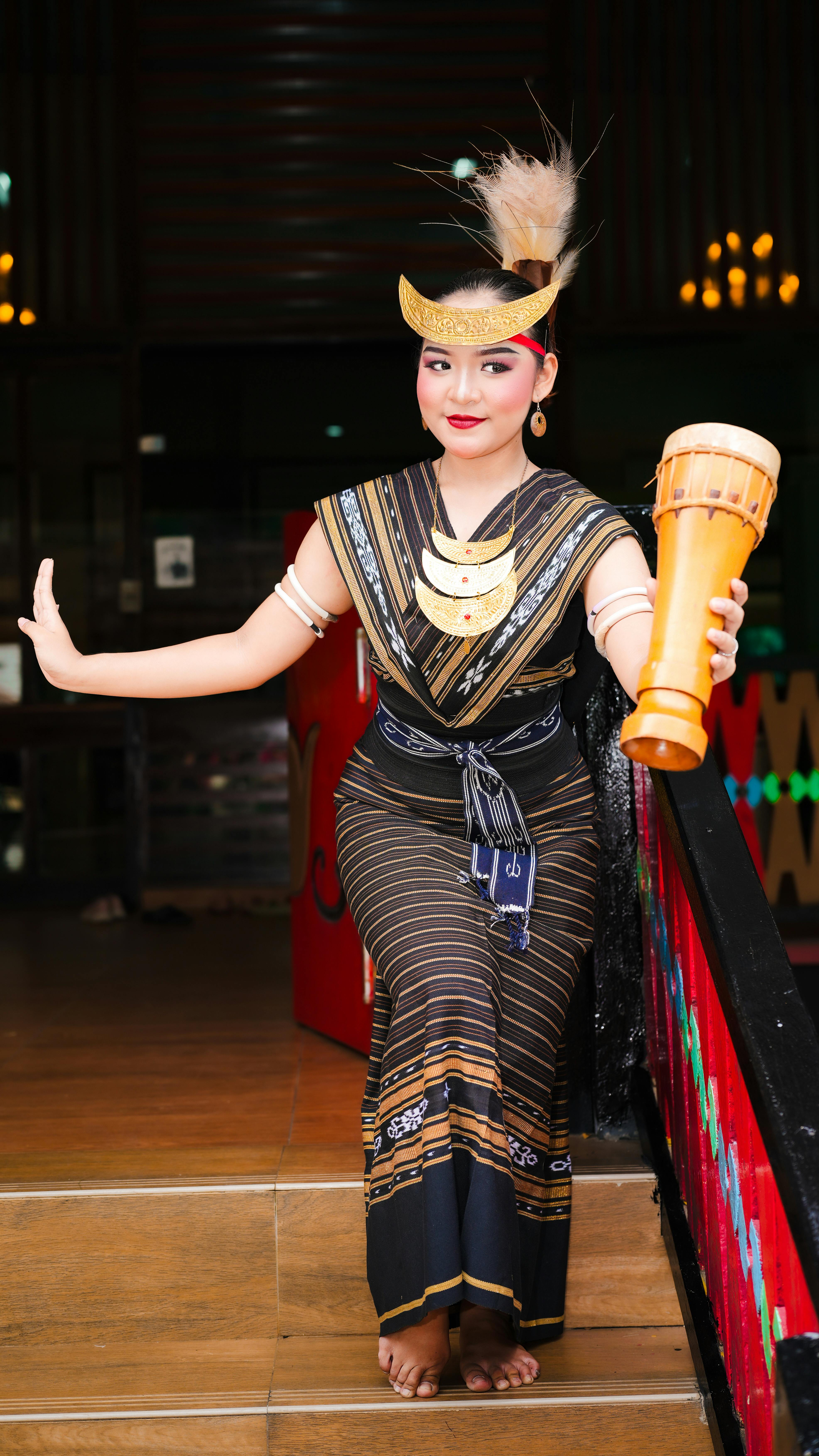Woman in traditional Indonesian dance costume, holding a drum, in Jakarta, Indonesia.
