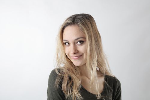 Free Portrait of a smiling woman with blonde hair on a white background. Stock Photo