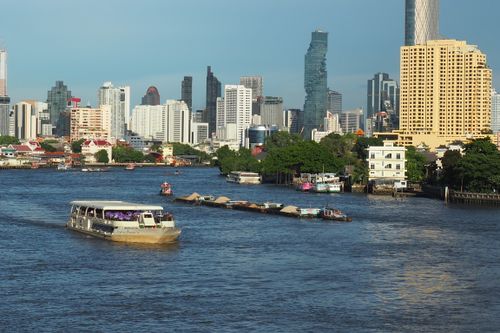 Free A vibrant city skyline with boats on a river, offering a lively urban scene. Stock Photo