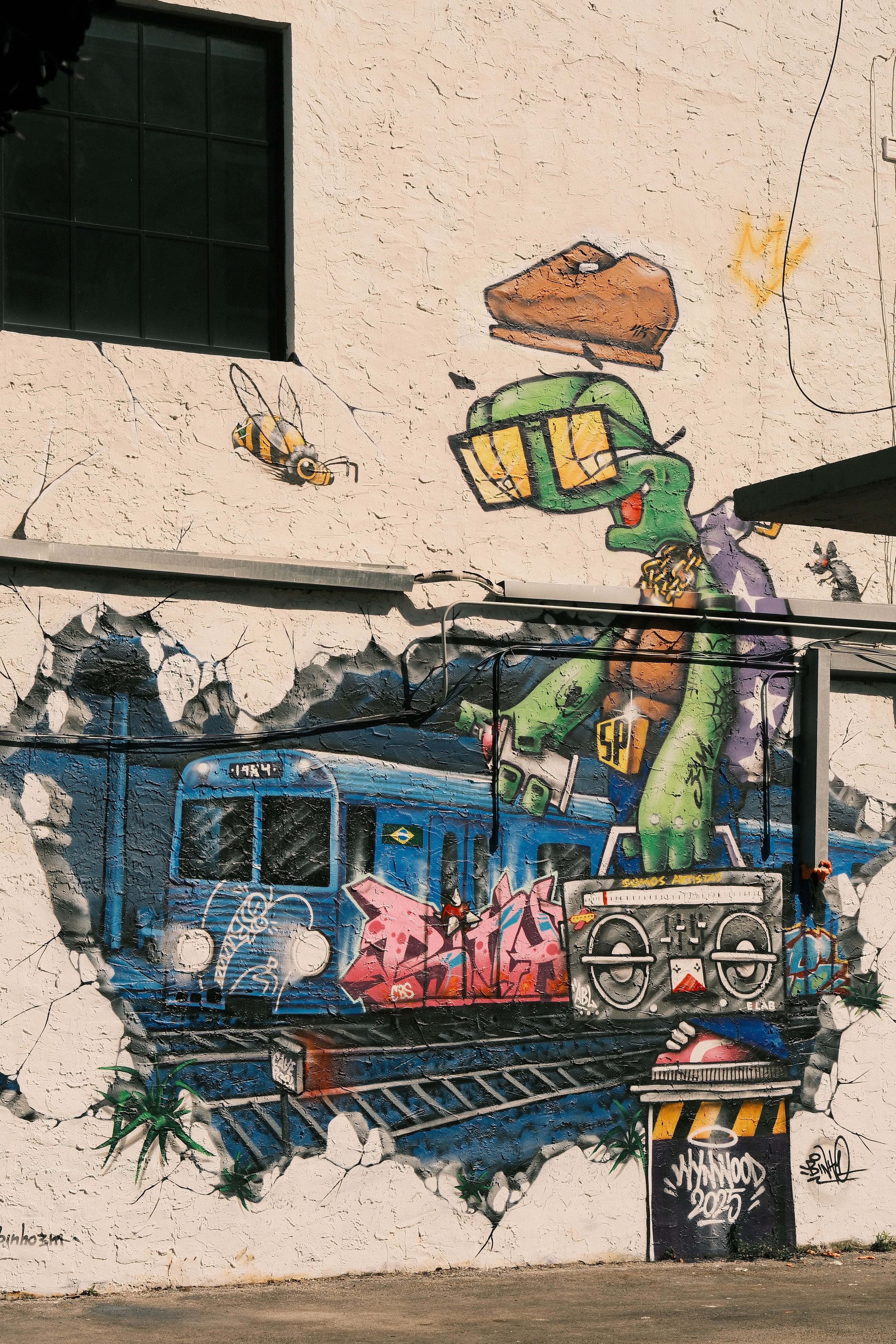 grátis Um mural vibrante de arte urbana com um personagem peculiar e grafites de trem, exalando cultura urbana. Foto profissional