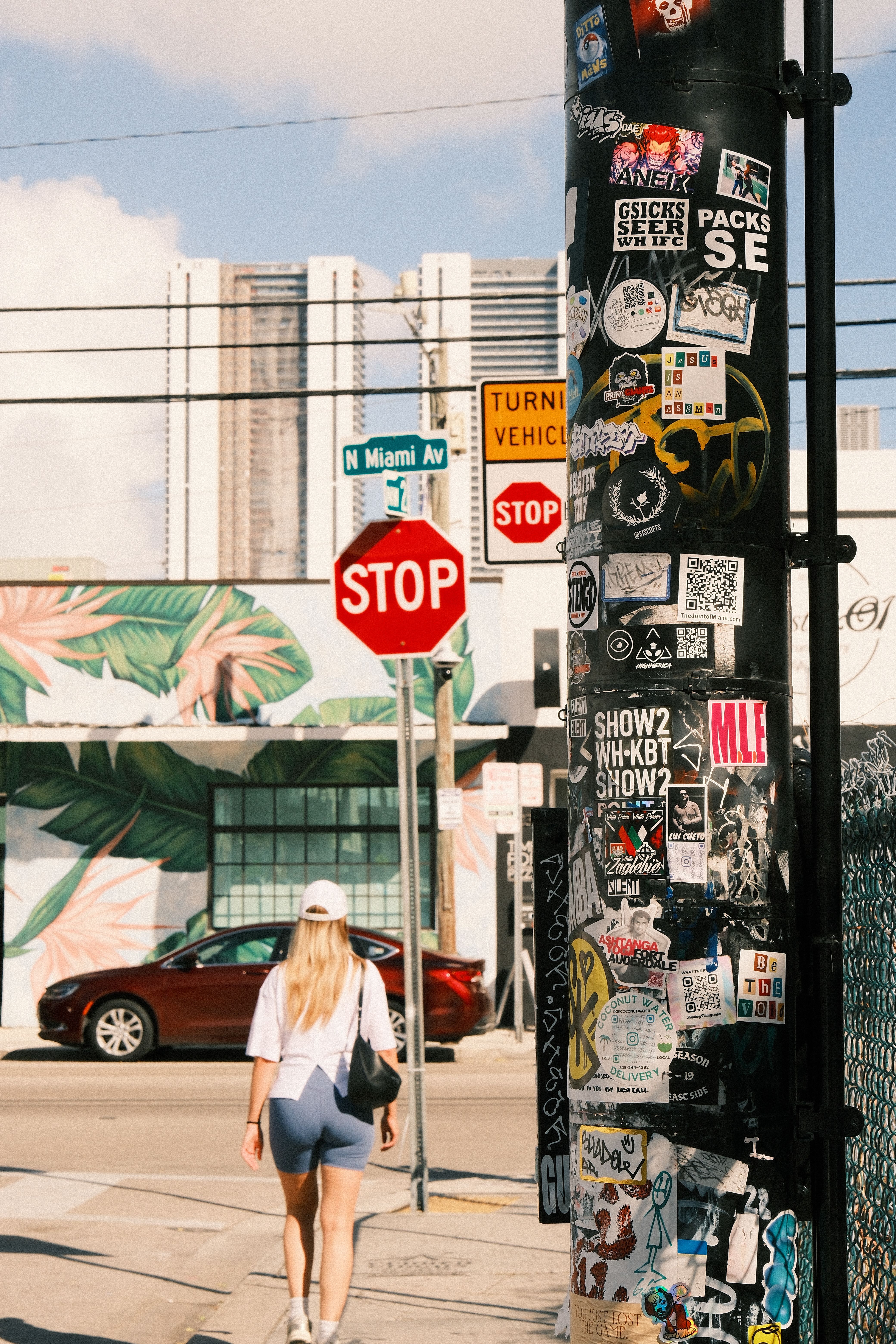 Vibrant street scene featuring stickers, a pedestrian, and Miami Avenue signage, capturing urban lifestyle.