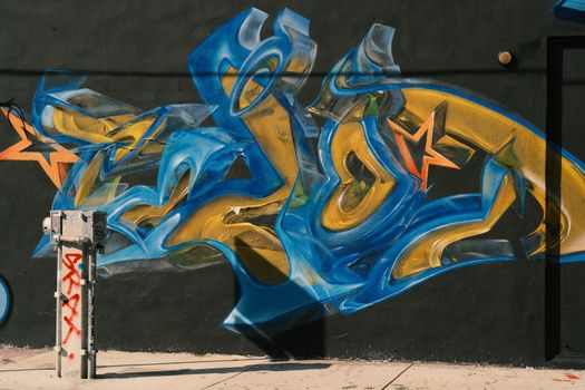 Colorful graffiti with star motifs on an urban wall, showcasing vibrant street art.