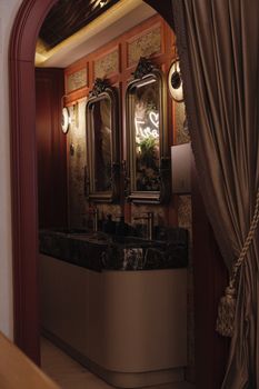 Elegant vintage bathroom interior with ornate mirrors and marble sink.