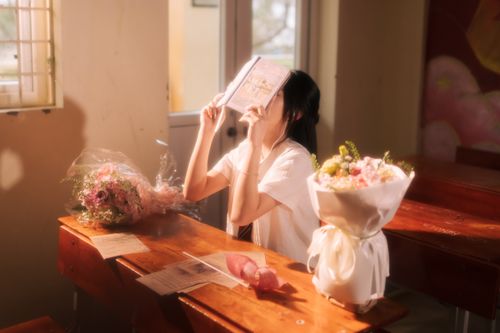 Free A young woman sits in a sunlit classroom with bouquets, creating a calm and reflective atmosphere. Stock Photo