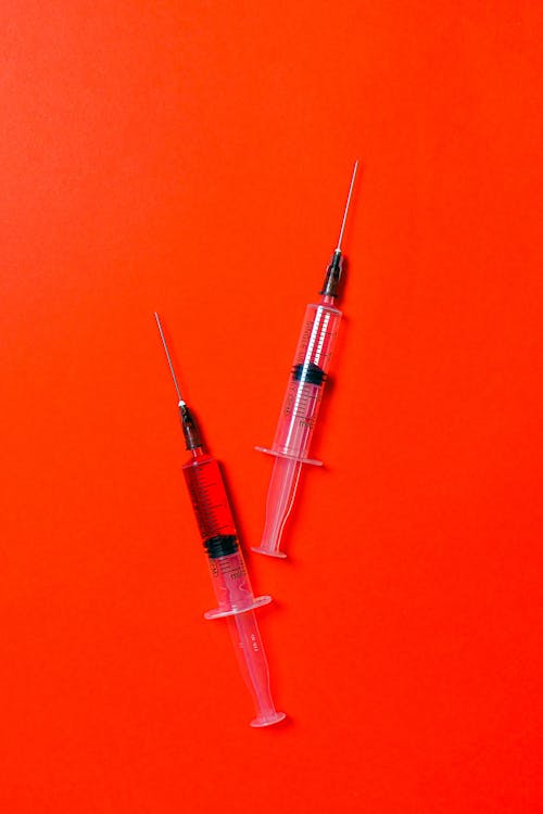 Free Syringes on Red Background Stock Photo