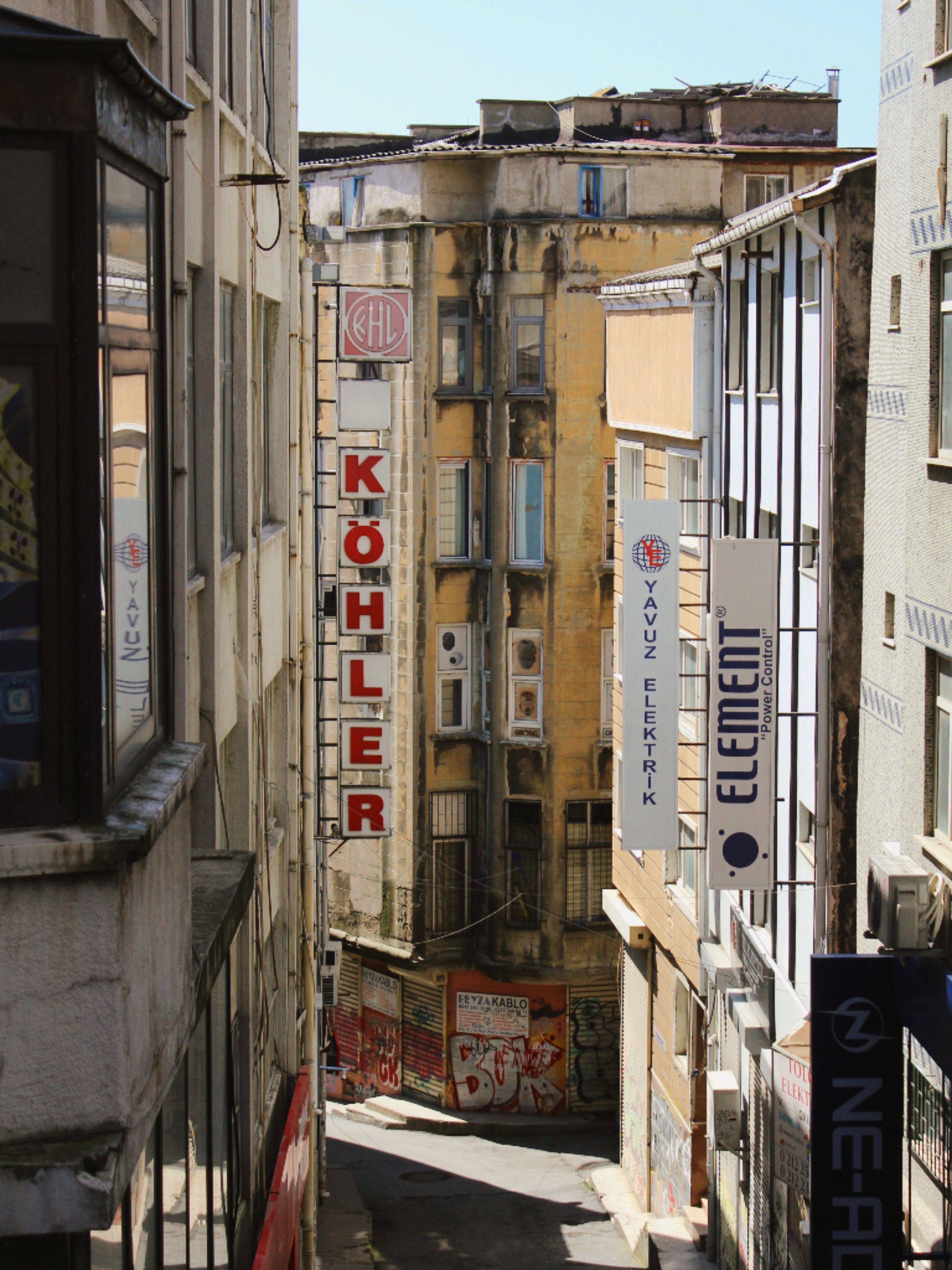 Explore the vibrant streets of İstanbul with signage and architecture in a narrow alleyway.