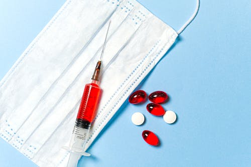 Free Syringe and Pills on Blue Background Stock Photo