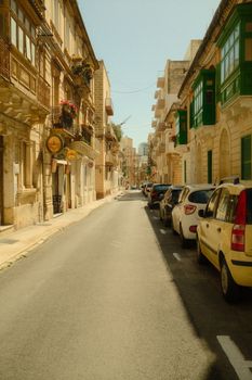 A picturesque street in Malta showcasing traditional architecture and vibrant colors.