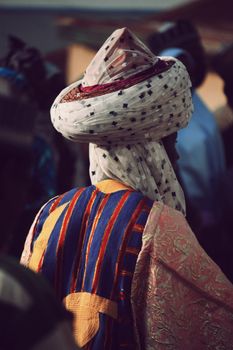 Person in traditional Nigerian attire with colorful textiles in Zaria.