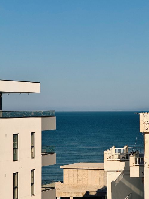 Free View of a modern building overlooking the serene sea in Sarandë, Albania. Stock Photo