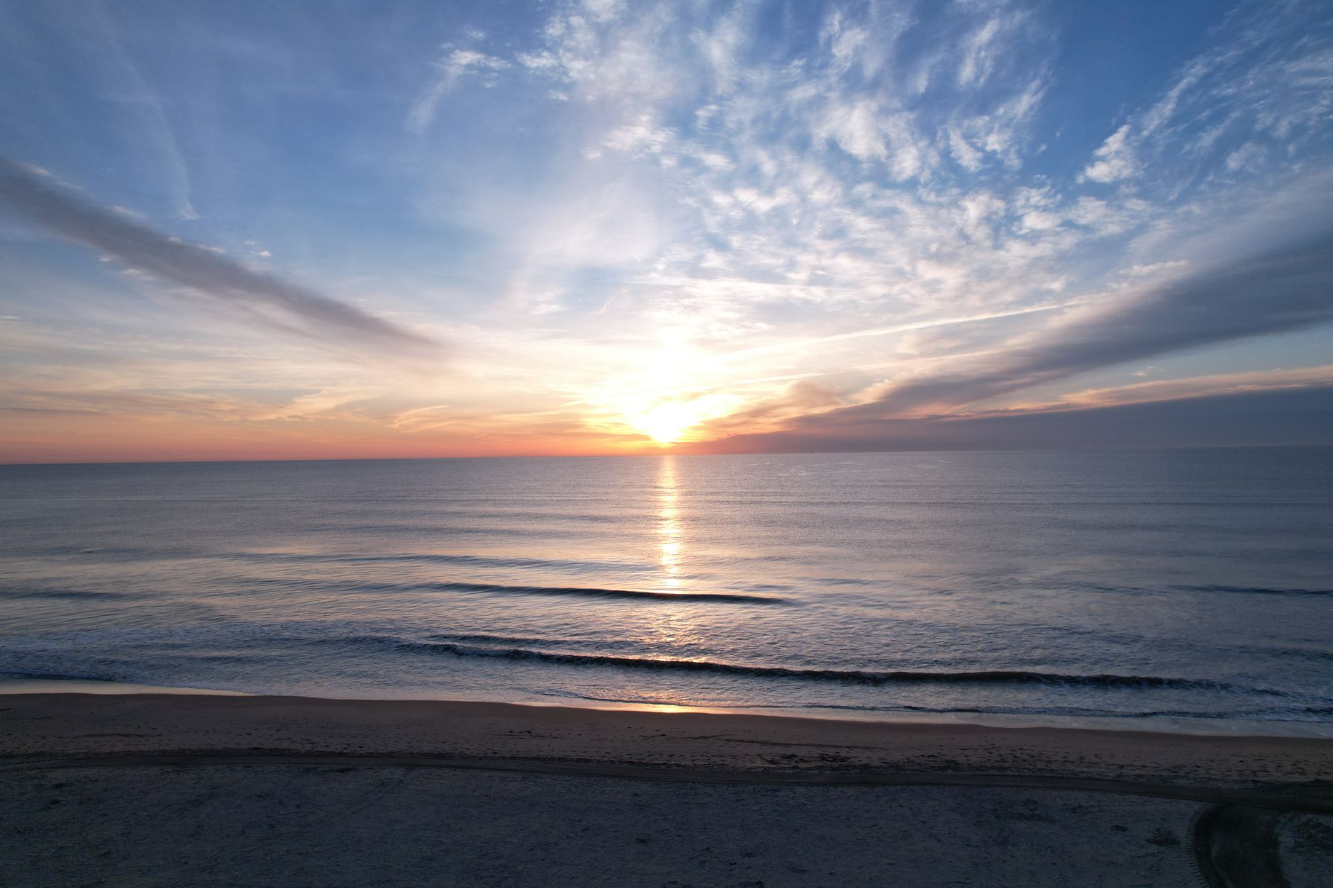Beautiful sunrise over Virginia Beach with gentle waves and vibrant skies, perfect for relaxation themes.