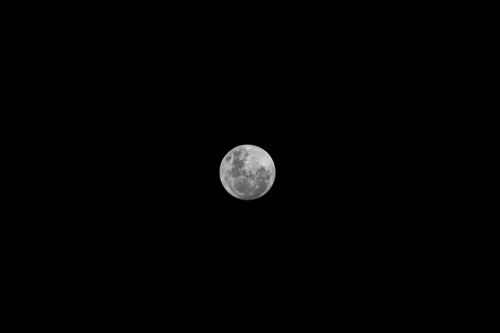 Free Close-up of the full moon against a black background highlighting lunar details. Stock Photo