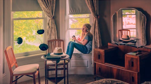 Free Girl Sitting Near a Window Wearing Headphone Stock Photo