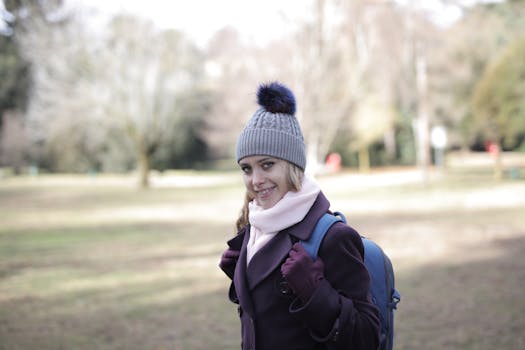 一位快乐的女子，背着背包、戴着无檐帽，在风景优美的公园里微笑