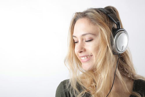 Woman in Gray Shirt Wearing Black Headphones