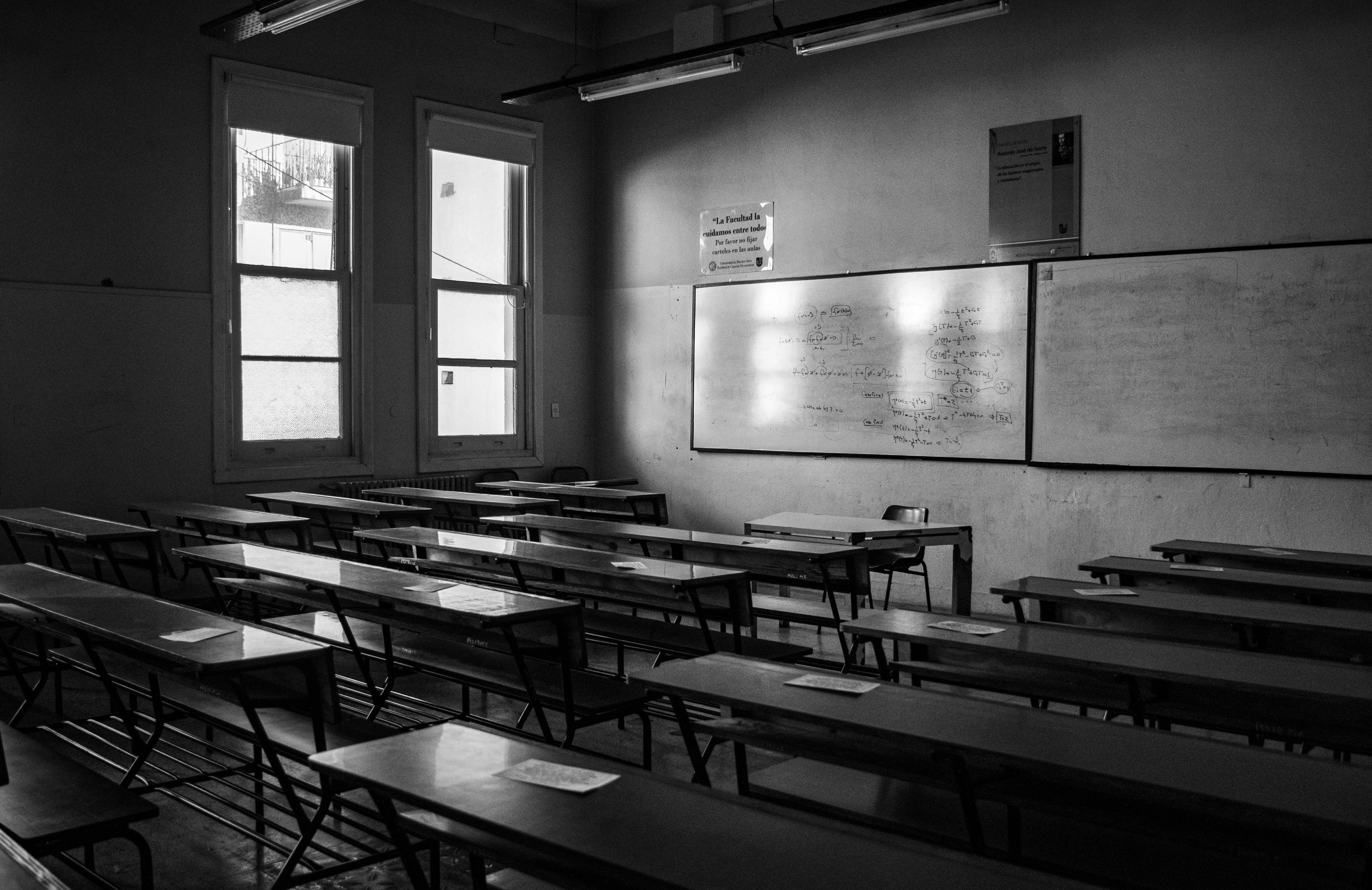 empty city classroom with wooden desks and afternoon light through tall windows