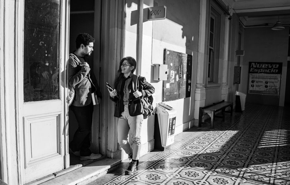 Two students engaging in conversation in a university hallway.