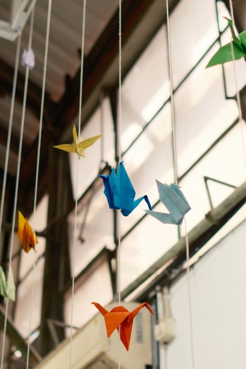 Free Vibrant origami cranes suspended in an indoor space, creating a whimsical atmosphere in Jakarta, Indonesia. Stock Photo