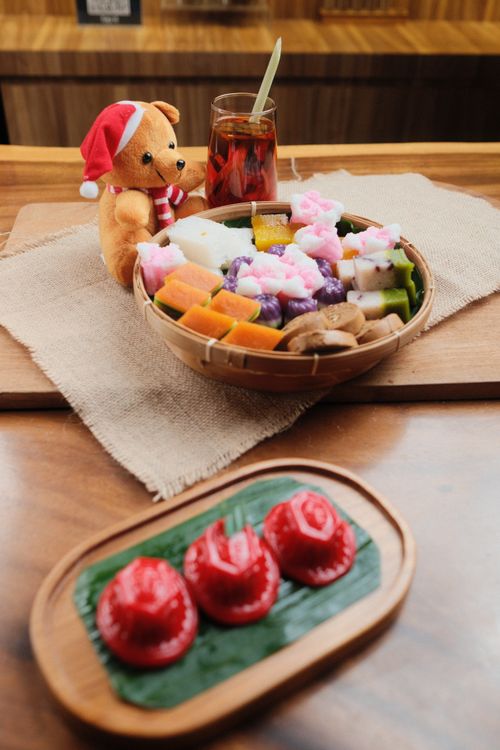 Free Plush bear with Santa hat beside a variety of Indonesian traditional sweets. Stock Photo
