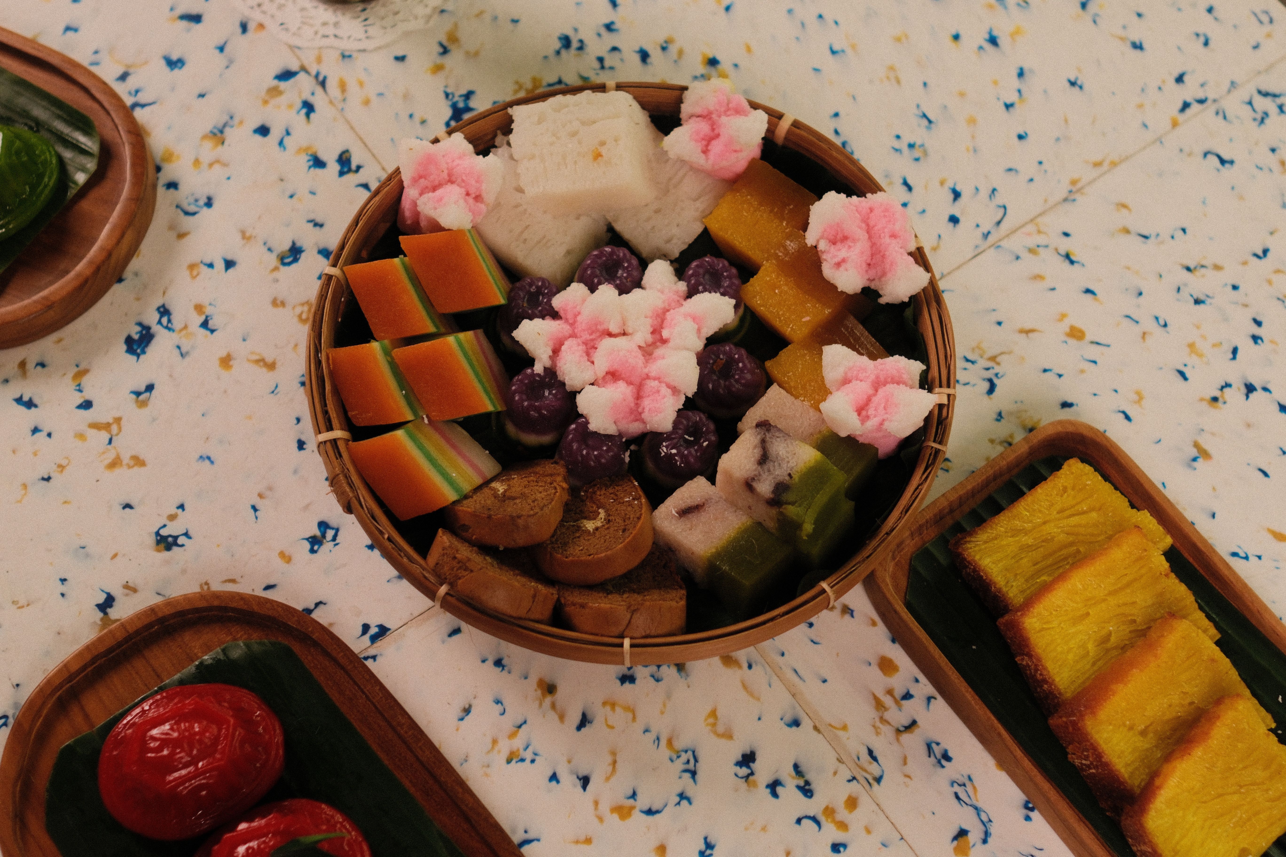 A vibrant display of traditional Indonesian sweets arranged on decorative platters.