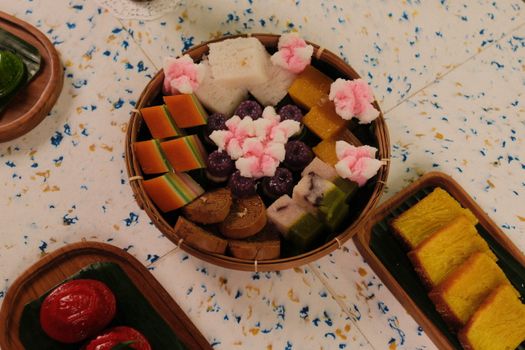 A vibrant display of traditional Indonesian sweets arranged on decorative platters.