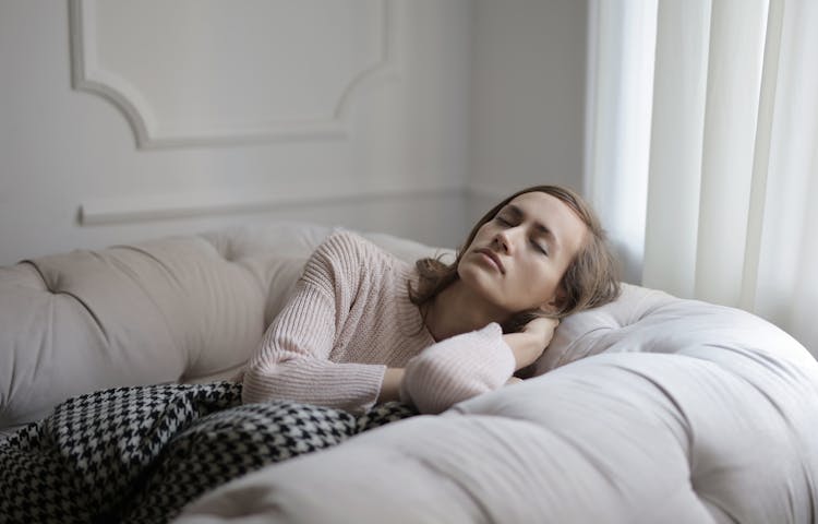 Girl In White Sweater Lying On Couch