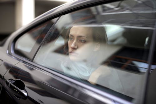 Woman Looking Out While Sitting Inside the Car