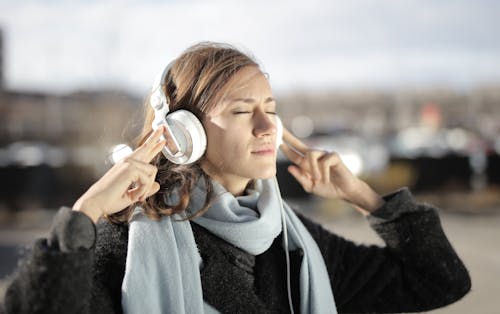 Shallow Focus Photo of Woman Using White Headphones