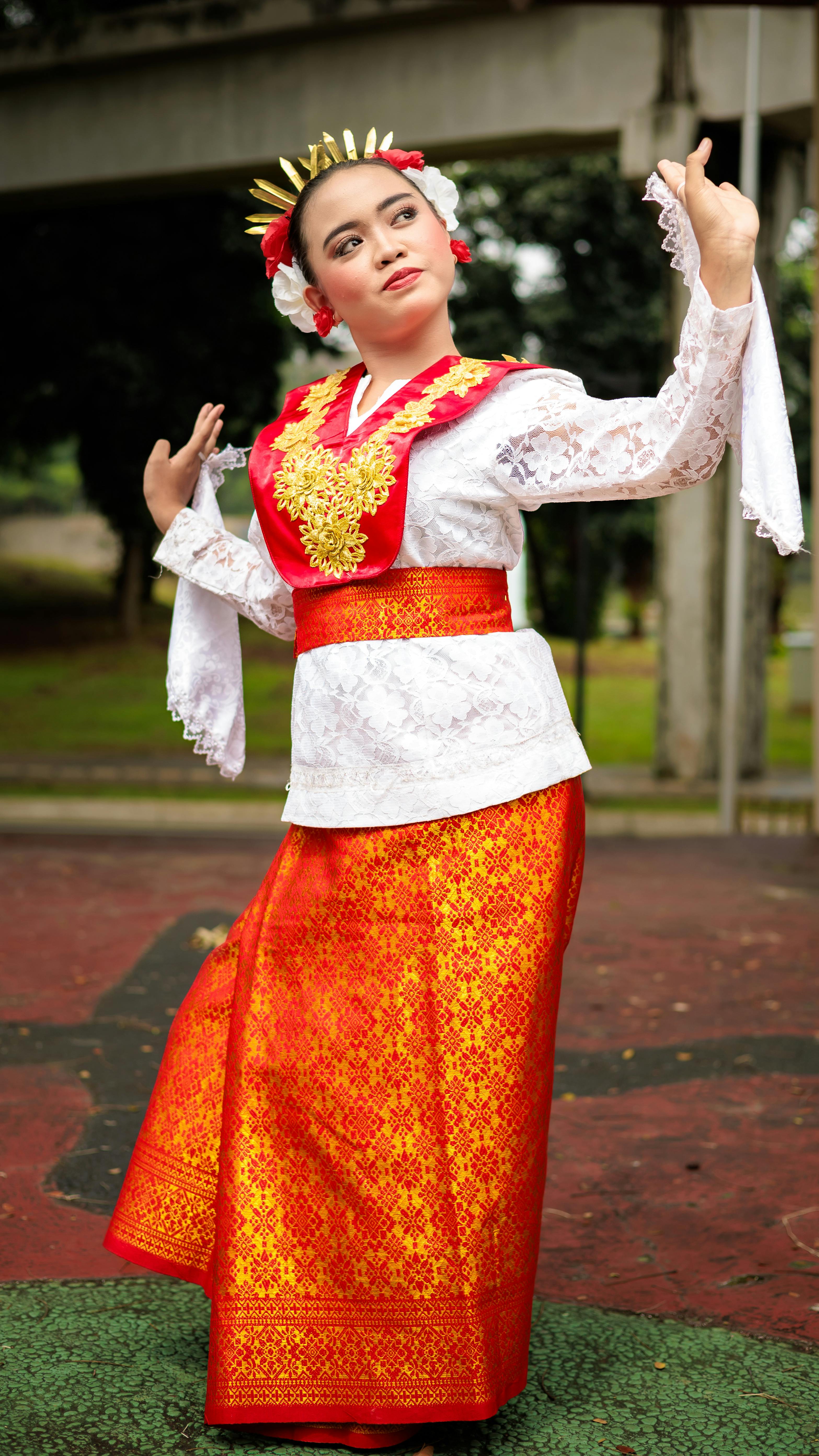 A female dancer in traditional Indonesian costume performing outdoors, exuding cultural vibrancy.