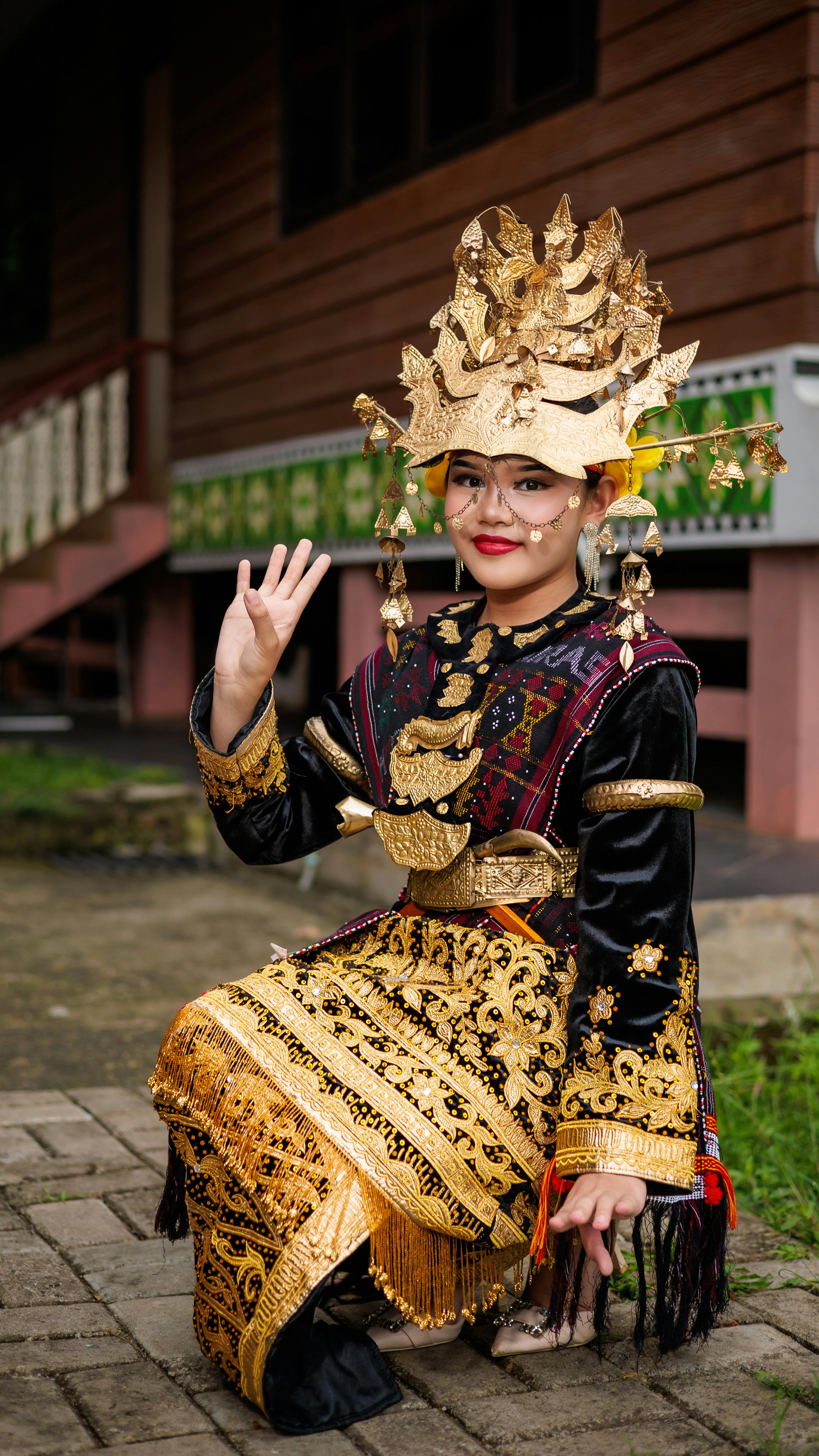 Woman in traditional Indonesian attire with intricate gold details photographed in Jakarta.
