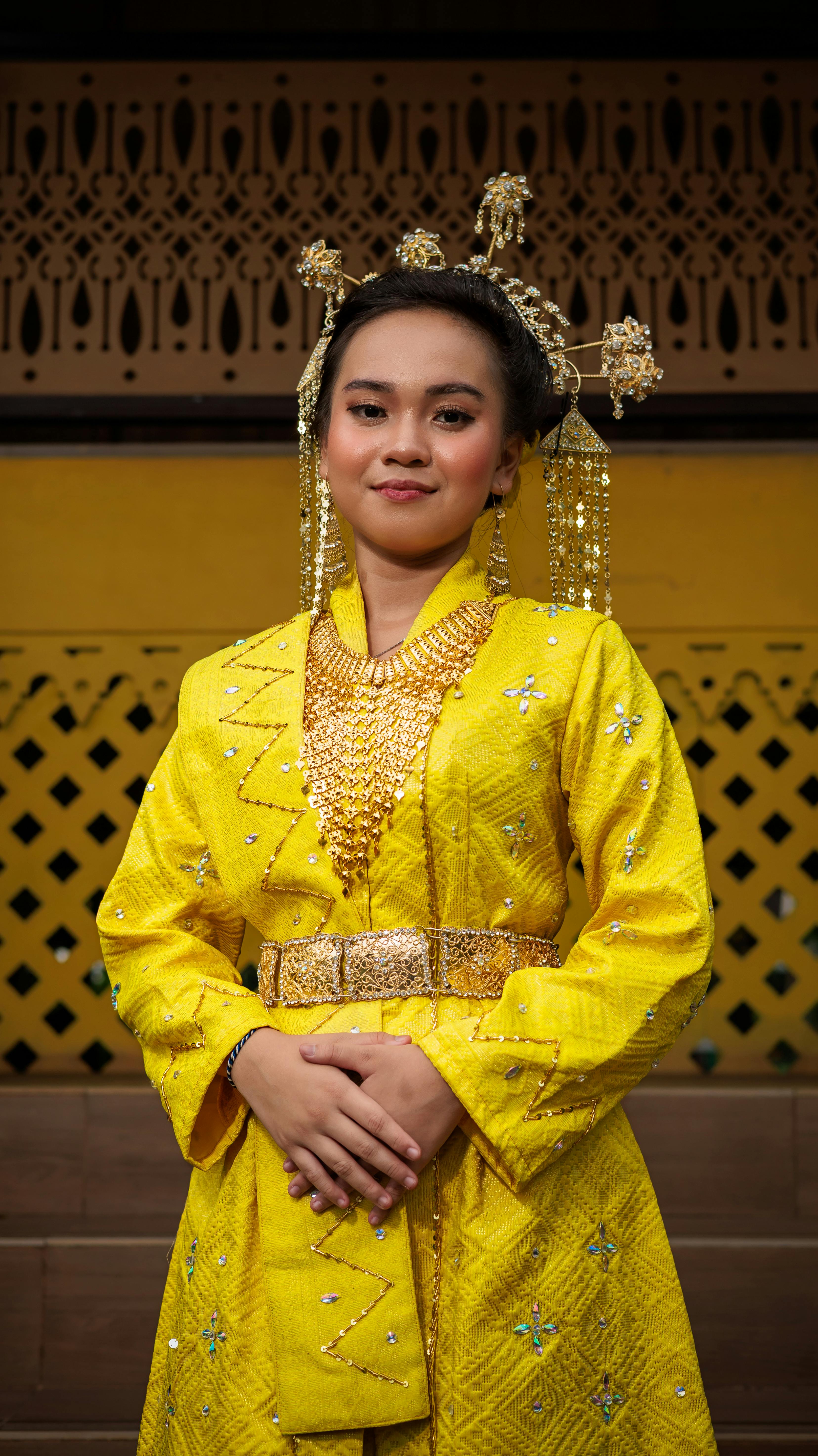 Portrait of a woman in traditional Indonesian attire with intricate jewelry.