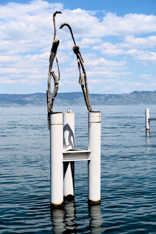 Free Sculpture emerging from Lake Geneva with picturesque mountains in the background in Evian, France. Stock Photo