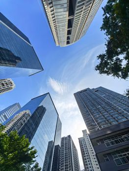A stunning upward view of gleaming skyscrapers against a clear blue sky in the Philippines.