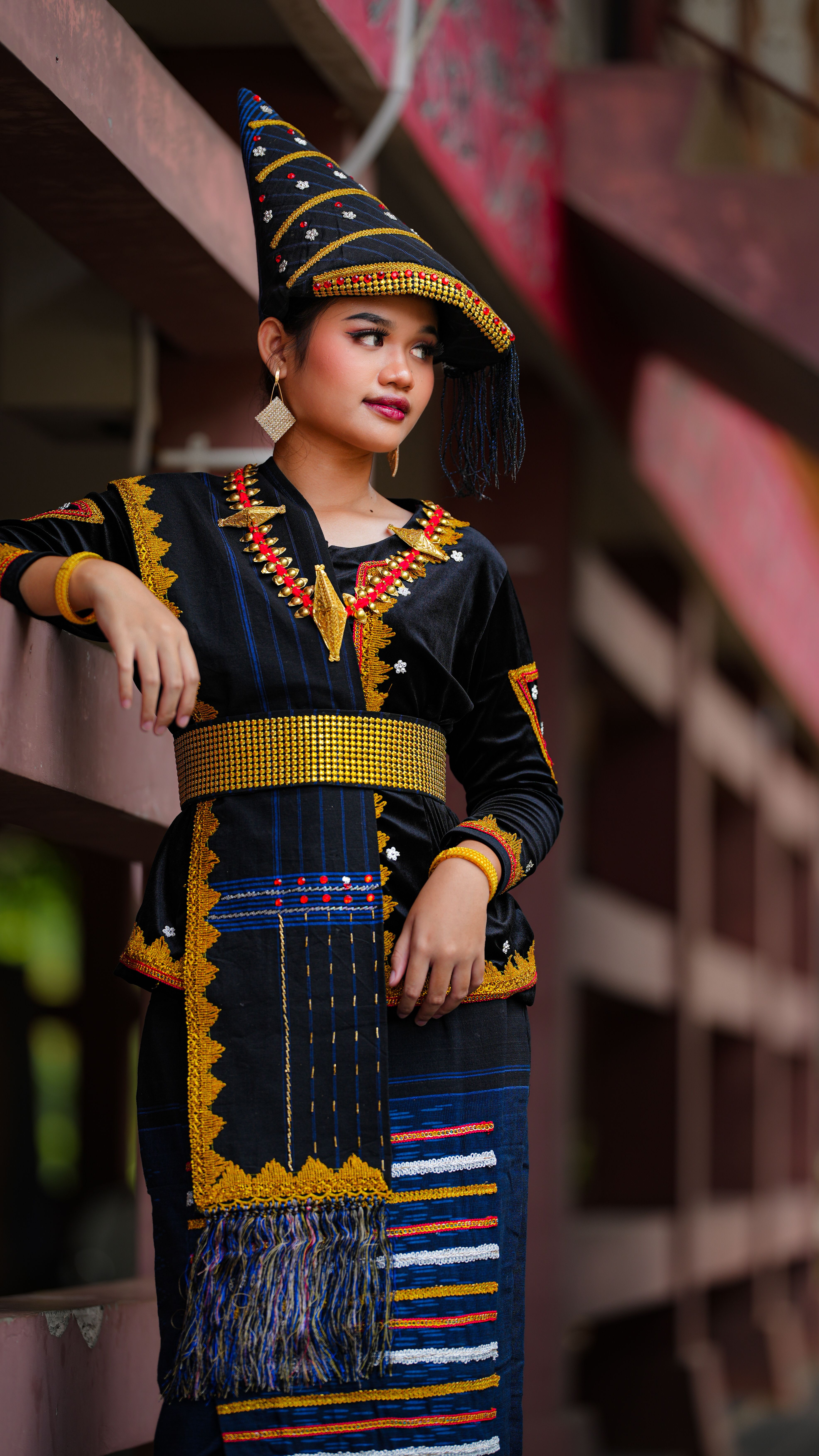 Young woman in vibrant traditional Indonesian attire posing outdoors in Jakarta.